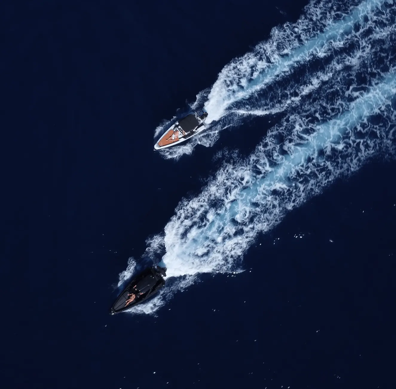 Drone shot showcasing Compass and Saxdor powerboats racing over deep blue Atlantic Ocean off Tenerife coastline