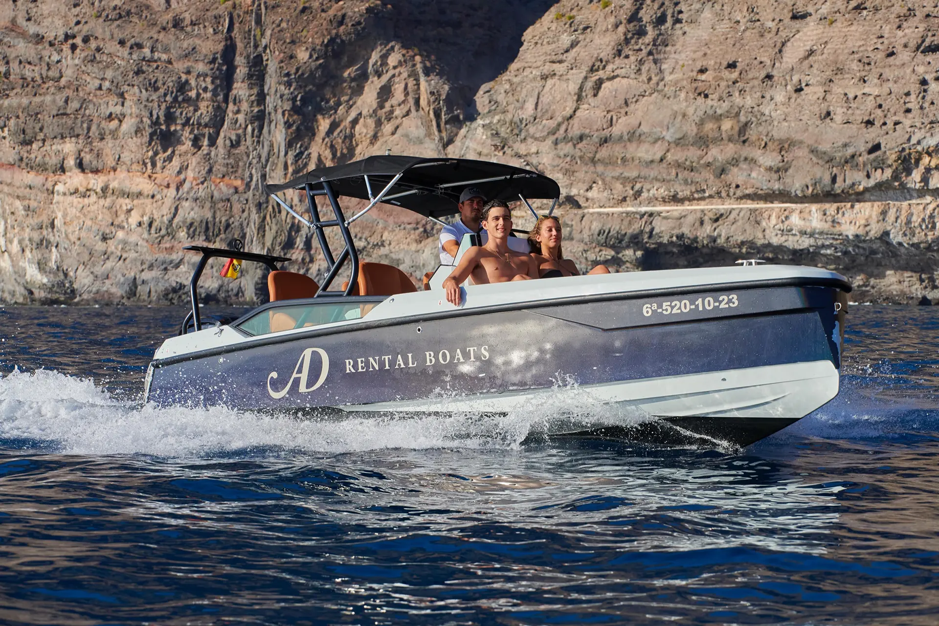 Couple with a skipper on a boat in the sea south of Tenerife's Los Gigantes cliffs